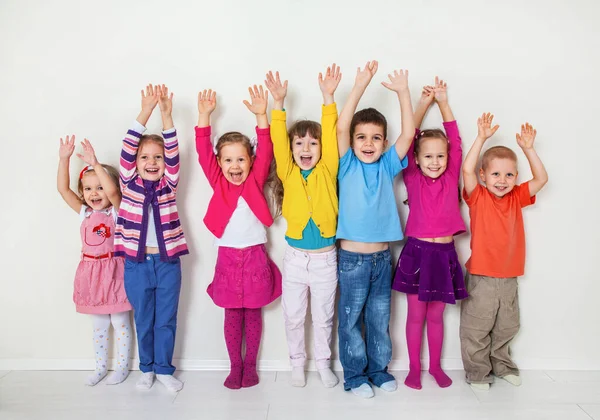 Gran Grupo Niños Diversos Con Las Manos Arriba Pared Blanca —  Fotos de Stock