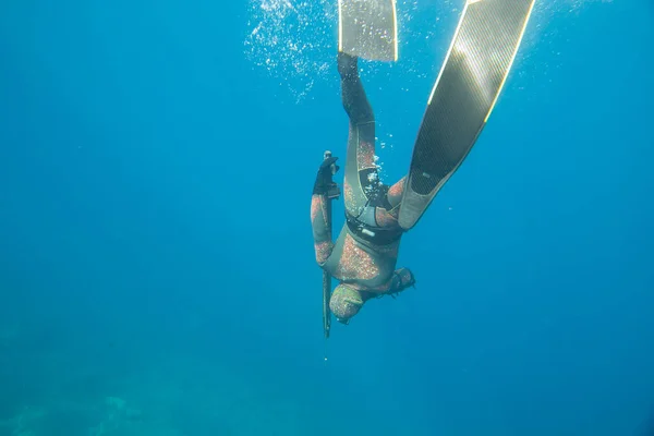 海の深さに潜る水中ハンターの銃で — ストック写真