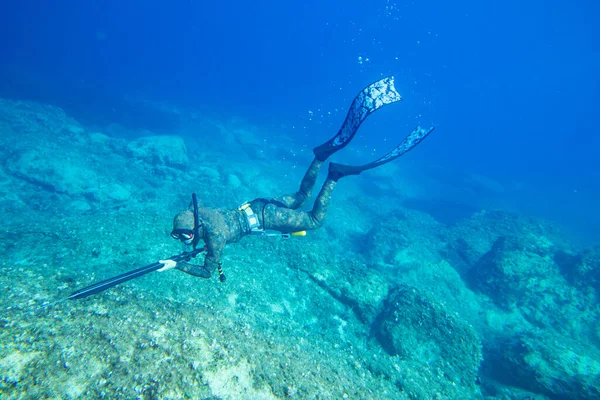 海の深さに潜る水中ハンターの銃で — ストック写真