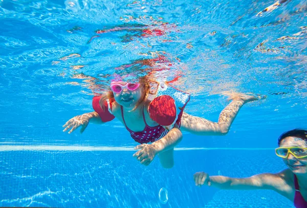 スイミングプールにいる少女と若い母親の水中写真 — ストック写真