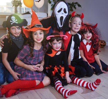 Kostümlü bir grup komik çocuk Cadılar Bayramı partisini birlikte kutluyor.