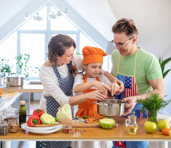 自宅のキッチンで一緒に若い子供の料理を持つ家族 — ストック写真