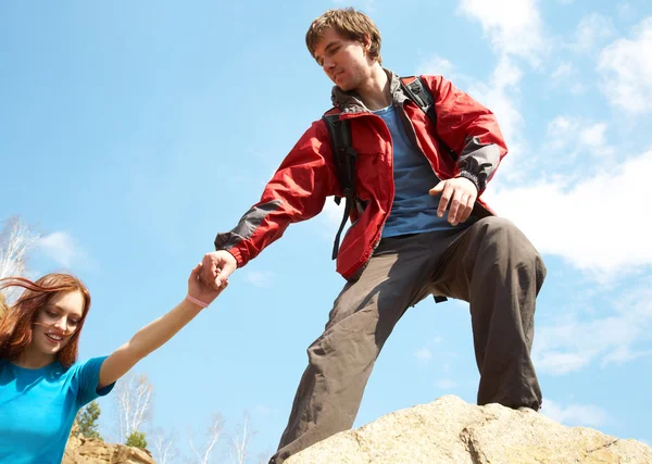 Wanderer reicht Frau die Hand — Stockfoto