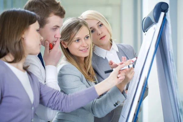 Mensen uit het bedrijfsleven schrijven op het schoolbord — Stockfoto