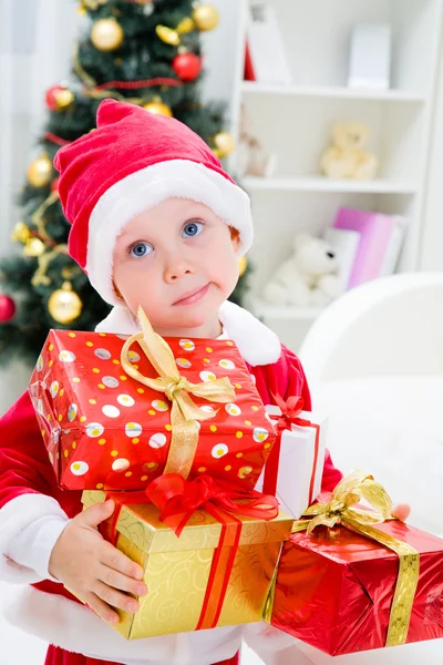 Pojken i santa kostym med julklapp — Stockfoto