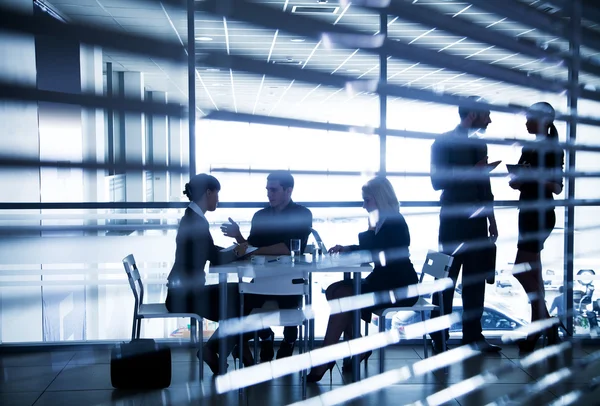 Silhouettes of businesspeople in office — Stock Photo, Image