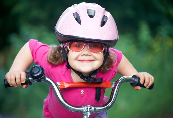 Bambina in casco in bicicletta — Foto Stock