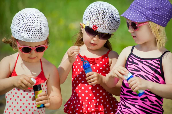 Tres niñas pequeñas soplan burbujas — Foto de Stock