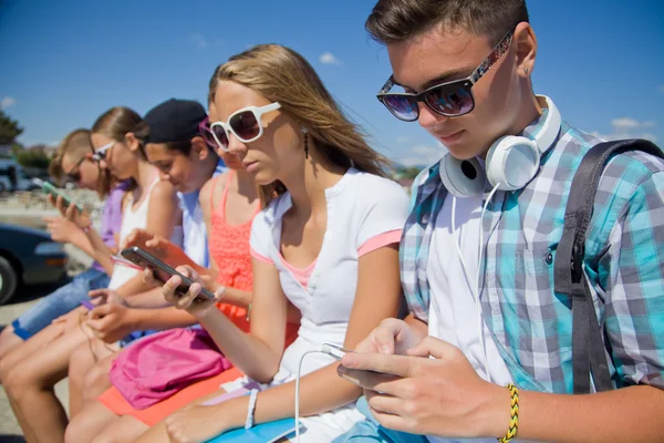 Group of teenagers with gadgets — Stock Photo, Image