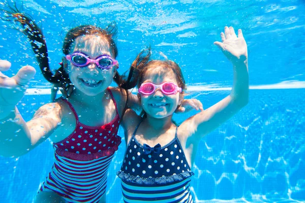 Duas meninas debaixo d 'água na piscina — Fotografia de Stock