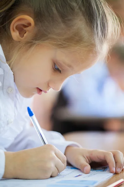 Scolaretta con penna scrittura — Foto Stock