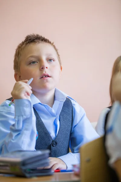 Écolier avec stylo en classe — Photo