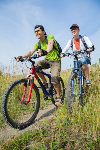 Couple of cyclists riding bicycles — Stock Photo, Image