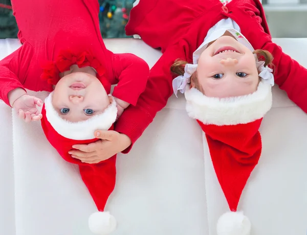 Девочки в Санта-Клаусах, лежащие сверху вниз — стоковое фото