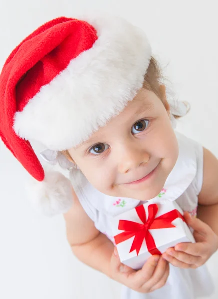 Ragazza in cappello di Babbo Natale contenente scatola regalo — Foto Stock