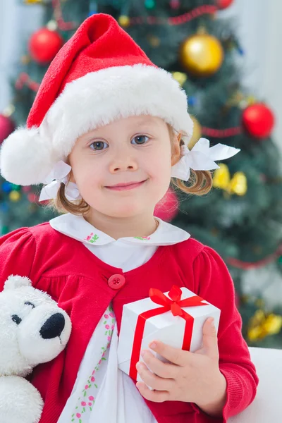 Girl in Christmas hat holding presents Stock Photo