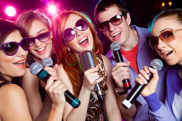 Jovens cantando na festa de karaoke — Fotografia de Stock