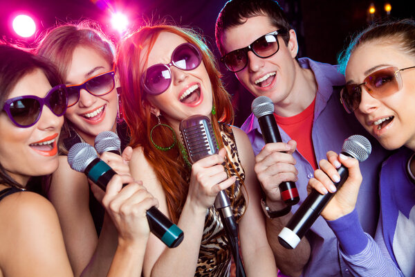 young people singing at  karaoke party