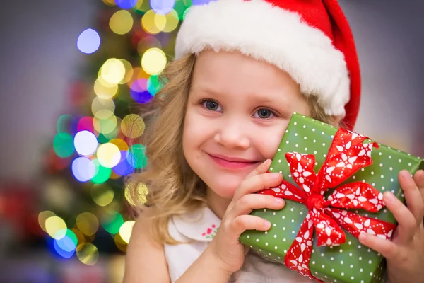 Meisje in Kerstman hoed met cadeau — Stockfoto