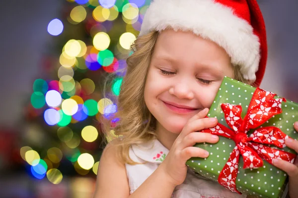 Meisje in Kerstman hoed met cadeau — Stockfoto