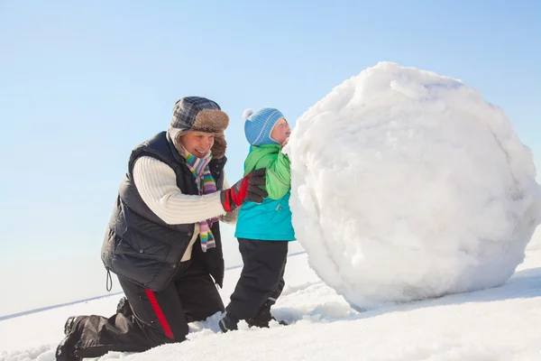 Man with son making big snowman — Stock Photo, Image