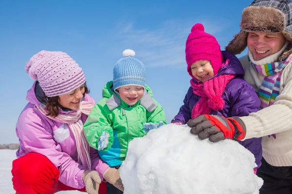 Paar mit Kindern bastelt großen Schneemann — Stockfoto