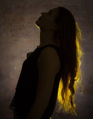 Genç ve güzel bir kadının altın ışığına karşı portre