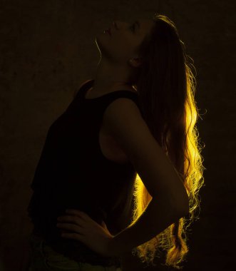 Genç ve güzel bir kadının altın ışığına karşı portre