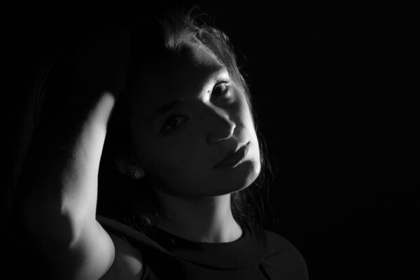 Black and white portrait of an Italian young woman on black background