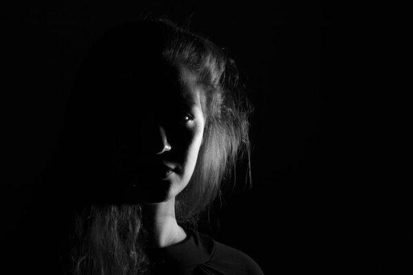 Black and white portrait of an Italian young woman on black background