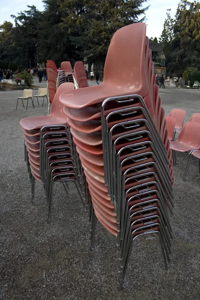 路上には赤いパルスと鉄の椅子が積み重なっている — ストック写真