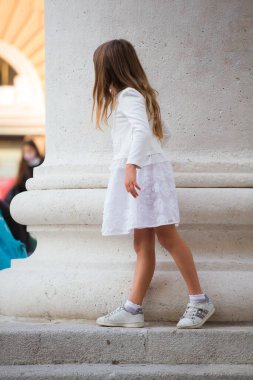 Trieste, İtalya - 10 Ekim: 10 Ekim 2020 'de sütunların yanında saklambaç oynayan güzel küçük kız