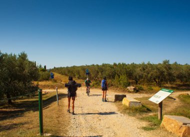 Strunian, Slovenya - 19 Eylül 2020 'de Strunjan Doğa Parkı yolunda bisiklet süren bir adama doğru yürürken sırt çantalı birkaç kız çocuğunun dikiz aynası