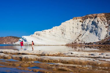 Scala dei Turchi 'ye bakan ve hayran olan bir çift. Realmonte, Agrigento 'da muhteşem bir denizde büyüleyici bir kireçtaşı dikeni. Sicilya 