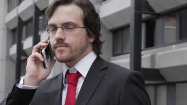 안경을 사업가가 스마트폰으로 이야기하는 — 비디오