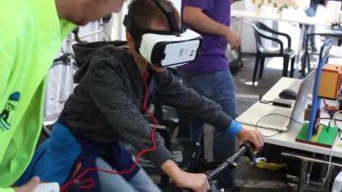 TRIESTE, ITALY - 17 Eylül 2017 'deki Trieste Mini Yapıcı Fuarı sırasında VR kulaklıklarıyla etkileşimli bisiklet eğitmeni