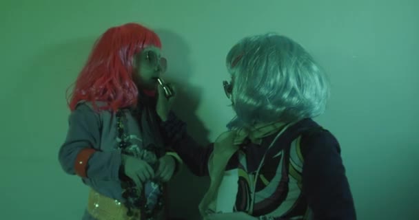 两个漂亮的孩子玩化妆品 涂口红准备去夜总会 迪斯科浅色背景 — 图库视频影像