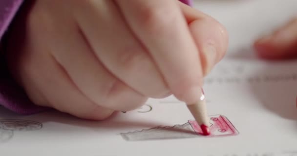 소녀의 가까이 빨간색 연필로 그림을 색칠하고 있습니다 — 비디오