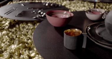 Şık çaydanlık, çay fincanı ve siyah terakottadan yapılmış yemekler.