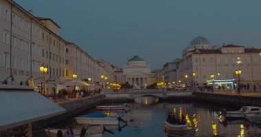 Trieste, İtalya - 31 Ekim: Sant 'Antonio Taumaturgo Kilisesi ve St. Spyridon Sırp Ortodoks Kilisesi' nin akşam manzarası.. Bunlar 31 Ekim 2020 'de Büyük Kanal' ın sonunda Aziz Antonio Nuovo olarak bilinen bir meydanda duruyor.
