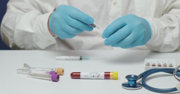 コロナウイルスワクチン検査中に注射器を使用して青い手袋を着用して医師の手を閉じる — ストック動画