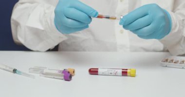 Coronavirus aşısı laboratuvar testi sırasında şırınga kullanarak mavi eldiven giyen doktorların fotoğraflarını çek.