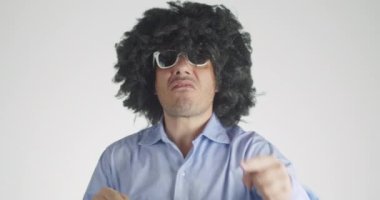 Kıvırcık saçlı bipolar bir adamın duygularını iyiden kötüye değiştirmesinin ön görüntüsü öfkeyle bağırmaya başladı ve hemen sonra gri arka planda pofuduk tavşancığını kucaklayıp kucaklamaya başladı..