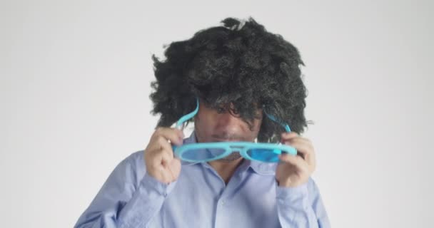 一个卷曲的头发 戴着令人心满意足的滑稽太阳镜 背景是灰色的 — 图库视频影像