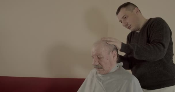Adam Evde Saç Makasıyla Beyaz Saçlı Bir Adamın Saçını Kesiyor — Stok video