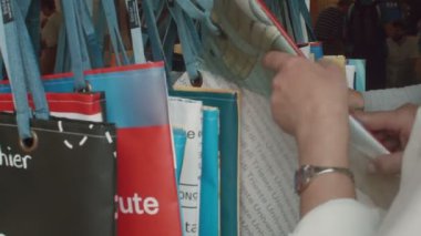 Çanta dükkanında elinde tutan ve bakan bir kadın.