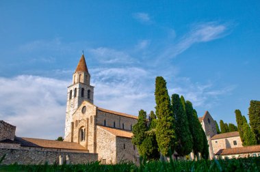 Aquileia 'daki Santa Maria Assunta Bazilikası' nın panoramik manzarası. Via Sacra 'da yer alır, Piazza del Capitolo' ya bakar, çan kulesi ve vaftiz töreniyle birlikte. İtalya 