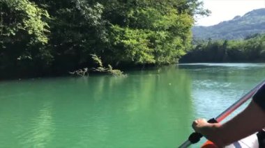 Güneşin altında kano gezisi. Slovenya 'nın Soca nehrinde dinlendirici bir günde kürek çeken bir kızın arka görüntüsü