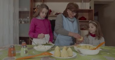 Torunları genç büyükannesine Arancini pişirmesinde yardım ediyor, tipik Sicilya yemekleri.