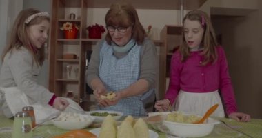 Torunları genç büyükannesine Arancini pişirmesinde yardım ediyor, tipik Sicilya yemekleri.